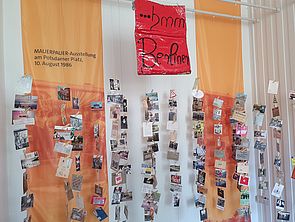 Auf dem Bild sind von der Decke hängende Postkarten zu sehen.