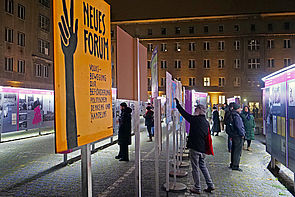 Auf dem Bild sieht man Menschen, die sich die Plakatausstellung "Haltet die Freiheit hoch" anschauen, die anlässlich des Jubiläums zu 35 Jahre Mauerfall.