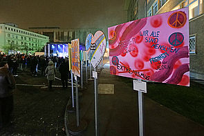 Auf dem Bild sieht man bunt gestaltete Plakate der Plakatausstellung "Haltet die Freiheit hoch", die anlässlich des Jubiläums zum 35-jährigen Mauerfalls ausgerufen wurde.
